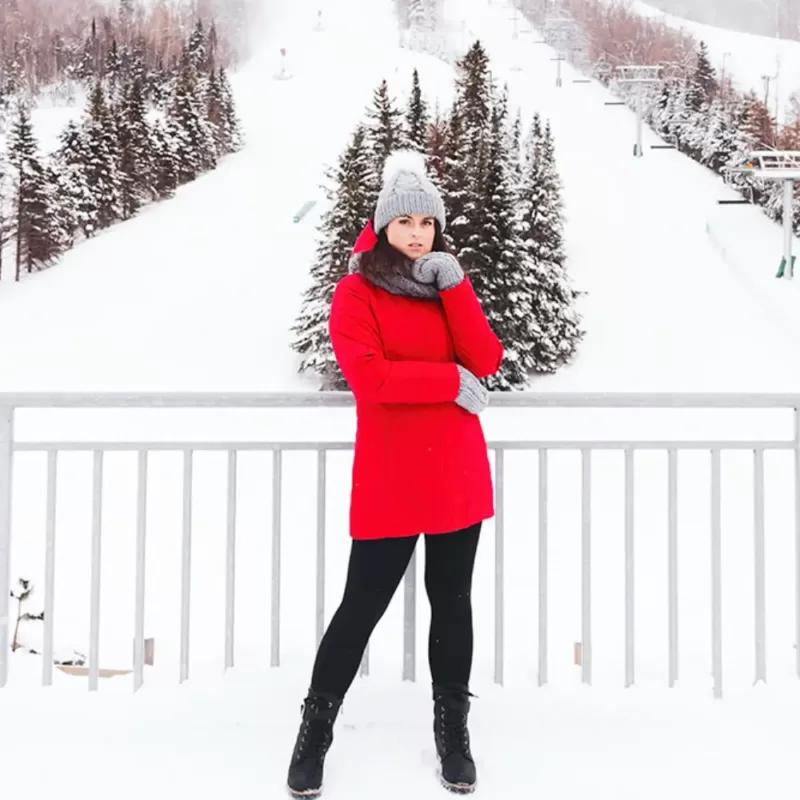 Our model is wearing the winter jacket NEW PICCA red at the ski resort.