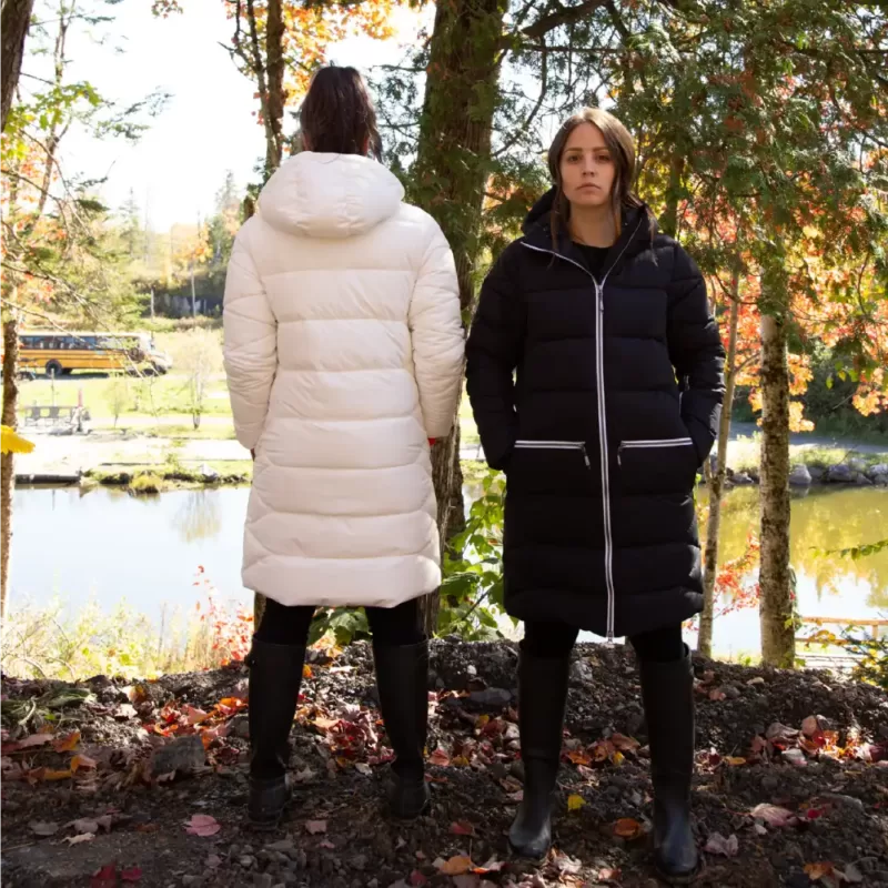 Our models wear the NEST winter jacket in black-white and white-orange for a walk in the great outdoors.