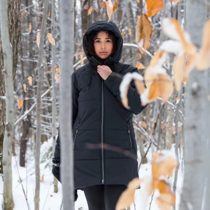 Model wearing black SPORTY winter jacket on a walk in the woods