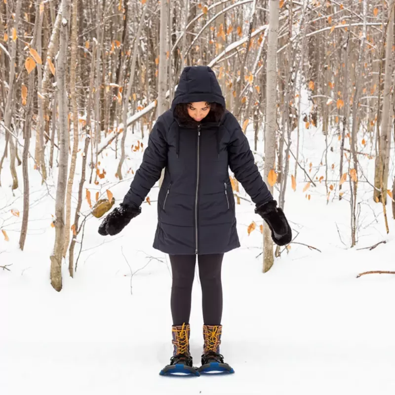 Model wearing black SPORTY winter jacket for snowshoeing in the woods
